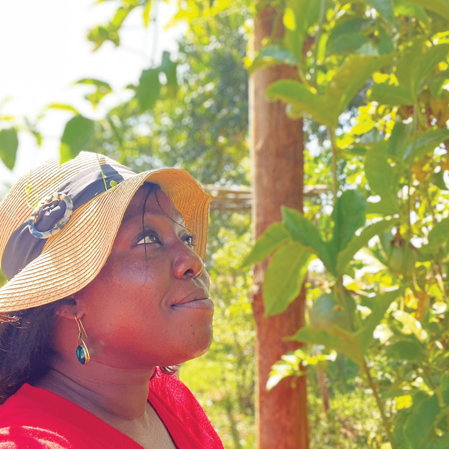 Teresa, founder and creative director at Shop Nanjala looking on at a purple grafted passion fruit tree